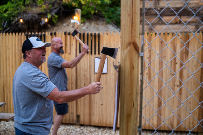 two men holding axes doing axe throwing in Maine