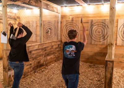 people throwing axes at an axe throwing range in Maine